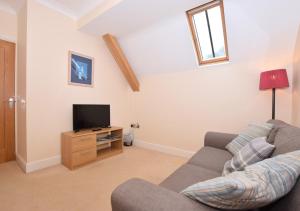 a living room with a couch and a tv at Chapel Loft in Lynmouth