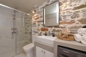 a bathroom with a sink and a mirror on the wall at Alesio's house in Ermoupoli +11 photos