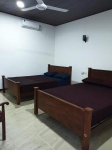 a bedroom with two beds and a couch and a ceiling at Florish Holiday Resort in Kataragama