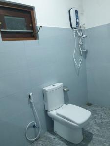 a bathroom with a toilet and a phone on the wall at Florish Holiday Resort in Kataragama