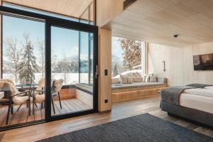 a bedroom with a bed and a balcony with a view at Alpenhotel Kitzbühel am Schwarzsee - 4 Sterne Superior in Kitzbühel