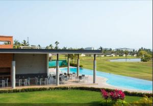 ein Resort mit einem Pool, Tischen und Stühlen in der Unterkunft New Villa Deluxe , Golf Club, Punta Cala 208 in Nuevo Vallarta