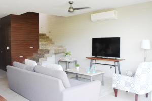 ein Wohnzimmer mit weißen Möbeln und einem Flachbild-TV in der Unterkunft New Villa Deluxe , Golf Club, Punta Cala 208 in Nuevo Vallarta