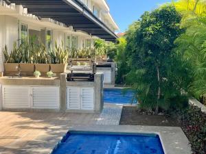 einen Hinterhof mit einem Pool und einem Haus in der Unterkunft New Villa Deluxe , Golf Club, Punta Cala 208 in Nuevo Vallarta
