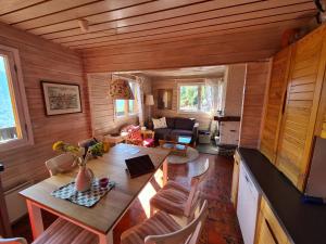 een woonkamer met een tafel en stoelen in een hut bij Porkka COSY & QUIET chalet 8 pers in Vex
