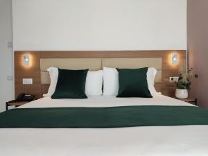 a bedroom with a large bed with green and white pillows at Massimi City Garden in Rome