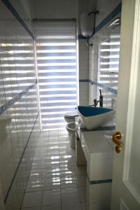 La salle de bains blanche est pourvue d'un lavabo et de toilettes. dans l'établissement G & G Appartamento nuovo, moderno e grazioso., à San Nicandro Garganico