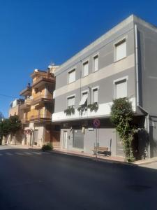 un bâtiment sur le côté d'une rue avec un banc dans l'établissement G & G Appartamento nuovo, moderno e grazioso., à San Nicandro Garganico