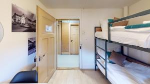 a small room with two bunk beds and a hallway at Solution-Grischun - Zentrales Dachzimmer - Kaffee&Tee - Gemeinschaftsbad - Etagenbett -Dachterrasse in Chur