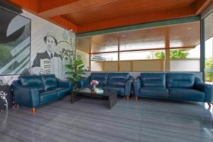 a living room with blue couches and a painting at The Bell Airport Phuket Hotel - SHA Extra Plus in Nai Yang Beach