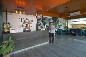 奈揚海灘的住宿－The Bell Airport Phuket Hotel - SHA Extra Plus，站在大厅柜台上的人