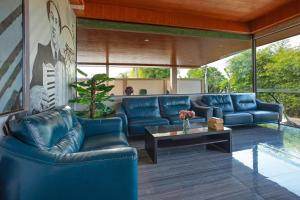 a living room with blue leather couches and a table at The Bell Airport Phuket Hotel - SHA Extra Plus in Nai Yang Beach