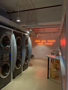 a laundry room with three washing machines and a table at lyf Cebu City managed by The Ascott Limited in Cebu City