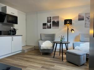 a living room with two chairs and a table at Top Apartment Zentrum Bad Urach in Bad Urach