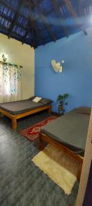 a room with two beds and a blue wall at The Camptime Forest Stay in Suntikoppa