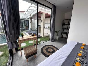 Schlafzimmer mit einem Bett, einem Schreibtisch und einem Fenster in der Unterkunft Bali Bird Villa Canggu in Dalung