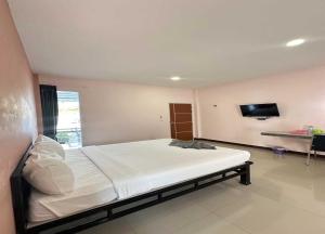 a bedroom with a large bed and a flat screen tv at OYO 75467 Baan Siripornchai2 in Takua Pa