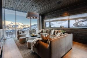 a living room with a couch and a large window at Tindekroken 5, Hemsedal in Fausko +7 photos