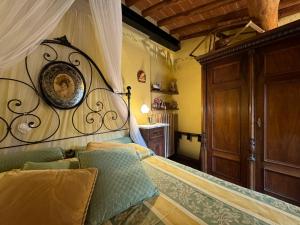 um quarto com uma cama com uma cabeceira de madeira em Casa Giulia, il gioiello del Borgo em Certaldo