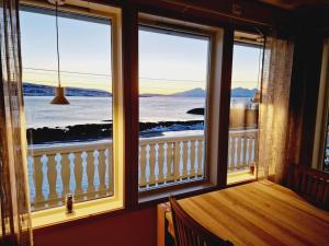 a room with two windows with a view of the ocean at Blabergan Lodge in Nord-Lenangen