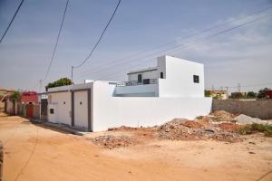 a white building on the side of a dirt road at Lovers Villa Somone in Somone