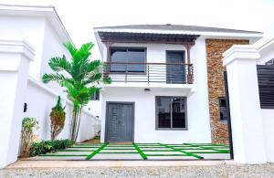 une maison blanche avec un palmier en face dans l'établissement AZURE - the perfect escape, à Tema
