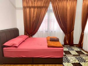 a bedroom with a bed with red sheets and a window at Rumah Tok Wan Dee (House 5 Rooms) 2024 in Wakaf Baharu