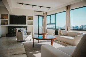 een woonkamer met banken en een tv en een tafel bij Phaedrus Living: Luxury City Center Penthouse in Limassol