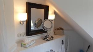 un miroir sur une étagère dans une salle de bain avec un lavabo dans l'établissement Gut-Rattelvitz-Galerie-D-hochwertig-Sauna-Kamin-eTankstelle-Spielscheune-15-000qm-Parkland, à Gingst 73 autres photos