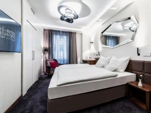 Habitación de hotel con cama y espejo en Hotel Royal en Stuttgart