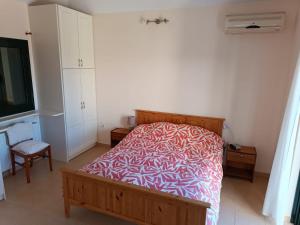 um quarto com uma cama com um cobertor vermelho e branco em Villa Margaux Karavados em Cefalônia