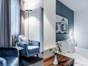 une chambre d'hôtel avec un lit et une chaise dans l'établissement Hotel Royal, à Stuttgart
