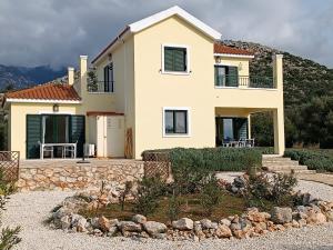 ein großes Haus mit einem Steingang davor in der Unterkunft Villa Margaux Karavados in Kefalonia