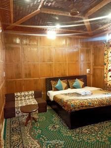 a bedroom with two beds and a chair in it at Hotel Kashmir Heaven in Srinagar