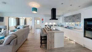 cocina y sala de estar con sofá y mesa en Shoreside Villa - immaculate waterfront property in Skelmorlie, en Skelmorlie