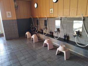 a public bathroom with four urinals and toilets at Hotel Shin-Imamiya in Osaka