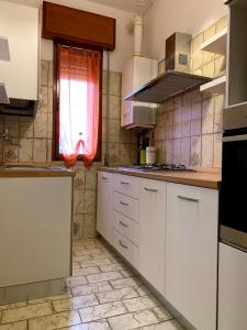 a kitchen with white cabinets and a window at CASA CORTE BOTTAZZI in Mirabello