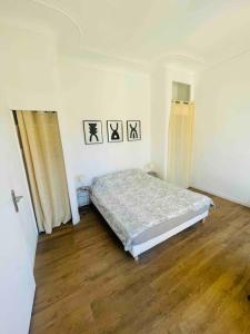 a bedroom with a bed and a wooden floor at Le Capucin - Au coeur de Marseille in Marseille