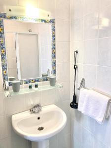 Baño blanco con lavabo y espejo en Hotel Villa Tokur, en Datça