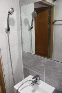 ein Bad mit einem Waschbecken und einem Spiegel in der Unterkunft Hostel JL in Chung-jeong in Seoul
