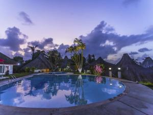 una piscina notturna con montagne sullo sfondo di Hotel Maribu Caribe a Puerto Limón