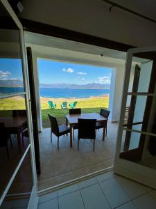 Cette chambre comprend une table et des chaises et offre une vue sur l'océan. dans l'établissement Résidence Punta paliagi, à Calcatoggio