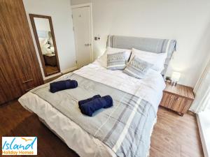 een slaapkamer met een bed met twee blauwe kussens erop bij Folly View in Newport