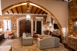 una gran sala de estar con una pared de piedra. en Oinoessa Traditional Boutique Guest Houses, en Lofou