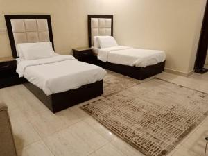 Dawmat al Jandalにあるدار السلام للشقق المخدومة الجوف دومة الجندلのベッドルーム1室(ベッド2台、ラグ付)