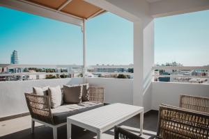 een patio met een bank en een tafel op een balkon bij Phaedrus Living: Luxury City Center Penthouse in Limassol