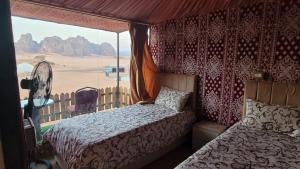 a bedroom with a bed and a view of the desert at Rum Grand Tours Camp in Disah