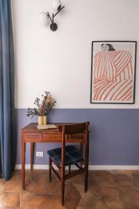 einen Schreibtisch mit einem Stuhl und einem Bild an der Wand in der Unterkunft Passepartout in Rom