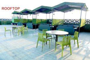 溫達文的住宿－Tulsi Garden- Near Prem Mandir Vrindavan，一组桌椅和遮阳伞
