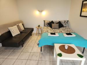 um pequeno quarto com uma cama e um sofá em Self Contained Guesthouse for 7ppl, w Pool em Gold Coast